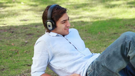 A-man-lies-on-the-ground-listening-to-his-headphones
