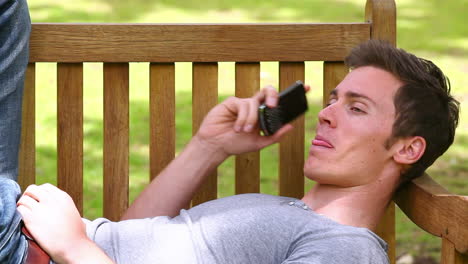 Man-laughing-and-talking-on-his-phone-before-hanging-up-and-looking-at-the-camera