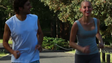 A-smiling-couple-look-to-one-another-as-they-jog