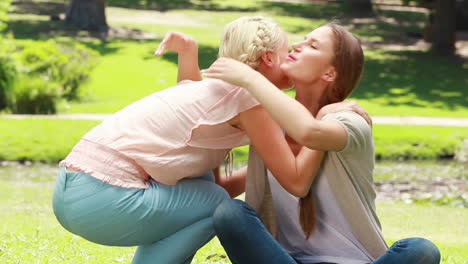 A-woman-sits-on-the-ground-and-then-her-friend-joins-her-as-they-look-upwards