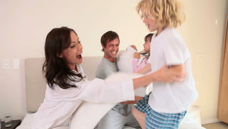 Smiling-family-having-a-pillow-fight