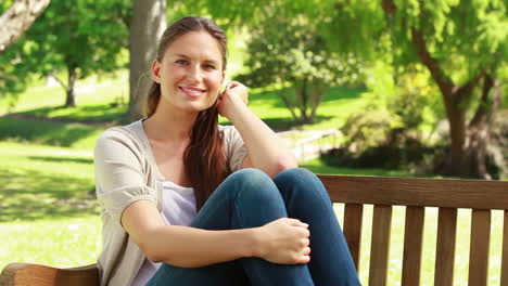 Smiling-woman-sitting-on-a-bench-