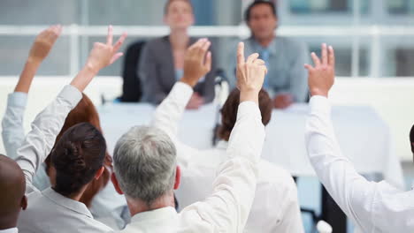 Business-people-raising-their-hands-to-ask-questions