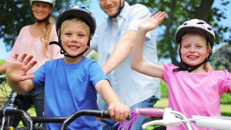 Camera-rises-to-show-a-family-sitting-on-bikes-as-the-children-wave-while-smilng