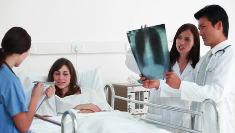 Doctors-talking-about-an-xray-scan-while-patient-is-talking-to-a-nurse