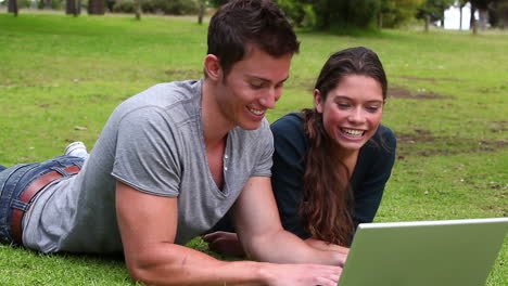 Zwei-Freunde-Unterhalten-Sich,-Während-Sie-Zusammen-Liegen-Und-Einen-Laptop-Benutzen