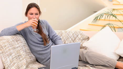 Woman-drinking-a-glass-of-wine-on-the-couch