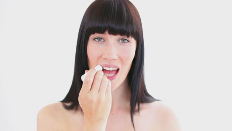 Smiling-woman-applying-lip-balm-on-her-lips