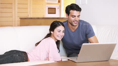 Smiling-couple-looking-at-a-laptop
