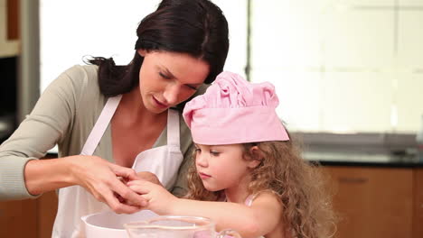 Mother-showing-her-daughter-how-to-open-an-egg