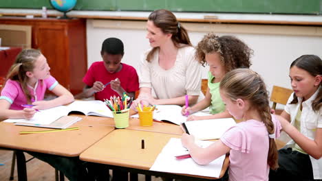 Lehrer-Sitzt-Mit-Schülern-An-Einem-Tisch