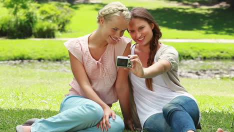 Dos-Mujeres-Posan-Para-Una-Foto-Y-Luego-Miran-El-Resultado-Y-Luego-Miran-A-La-Cámara