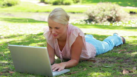 The-camera-shifts-focus-from-the-park-to-a-woman-on-her-laptop-as-she-reads