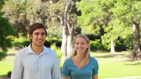 Couple-walking-up-to-the-camera-as-they-point-and-laugh-and-then-wave-into-the-camera