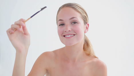 Smiling-woman-brushing-her-eyebrows