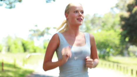A-woman-jogging-in-the-park-as-she-runs-in-front-of-the-camera