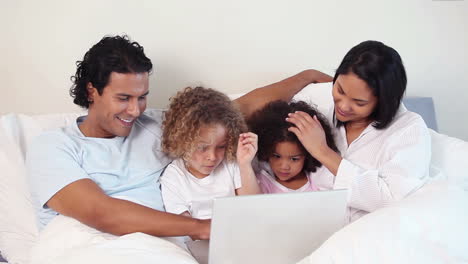 Familia-Viendo-Una-Película-En-La-Cama