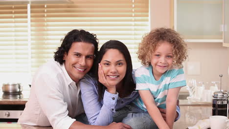 Familia-Sonriendo-A-La-Cámara-En-La-Cocina