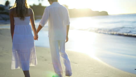 Mann-Nimmt-Seine-Freundin-An-Der-Hand,-Bevor-Sie-In-Richtung-Sonnenuntergang-Am-Strand-Gehen