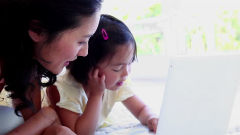 Mother-using-a-laptop-with-her-daughter