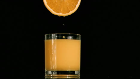 Tropfen-Fällt-In-Superzeitlupe-Von-Einer-Orangenscheibe-In-Einem-Vollen-Glas