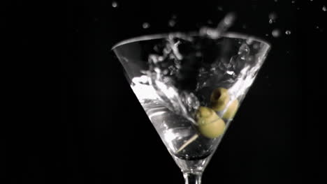 Olive-skewer-falling-in-super-slow-motion-in-a-glass