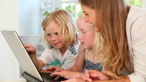 Mother-using-a-laptop-with-her-children