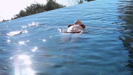 Woman-lying-on-the-back-in-a-swimming-pool