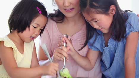 Daughters-helping-their-father-toss-salad