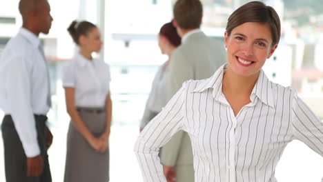 Smiling-business-woman-with-her-hands-on-her-sides