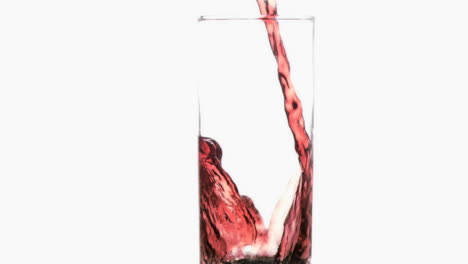 Red-thin-trickle-in-a-super-slow-motion-flowing-in-a-glass-