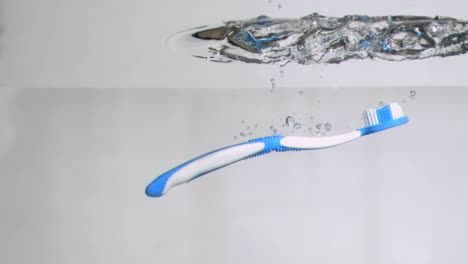 One-blue-toothbrush-in-a-super-slow-motion-falling-in-water-