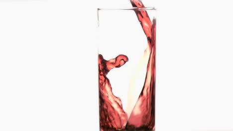 Red-thin-trickle-in-a-super-slow-motion-flowing-in-a-stemmed-glass-