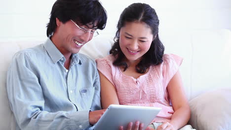 Couple-smiling-as-they-use-a-tablet-computer