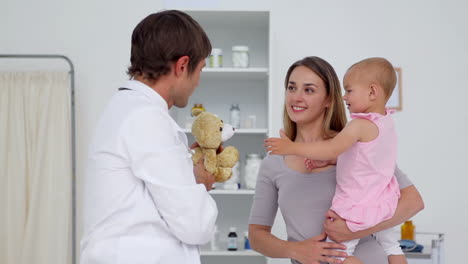 Doctor-giving-a-teddy-bear-to-a-baby