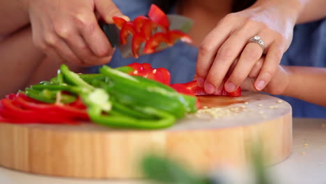 Girl-cutting-peppers-with-a-parent