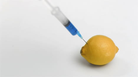 Syringe-in-super-slow-motion-falling-on-a-lemon