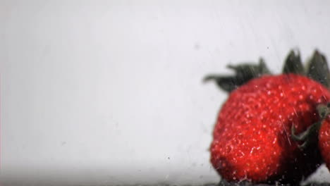 Water-in-super-slow-motion-falling-on-red-fruits