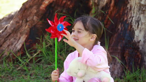 Smiling-girl-holding-a-red-pinwheel