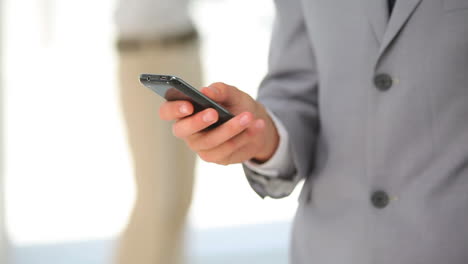 Man-in-a-suit-typing-on-his-phone