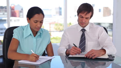 Welldressed-people-writing-on-organizer