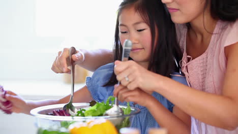 Daughter-mixing-a-salad-with-her-mother