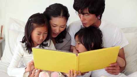 Familia-Leyendo-Un-Libro-Mientras-Se-Sientan-Juntos