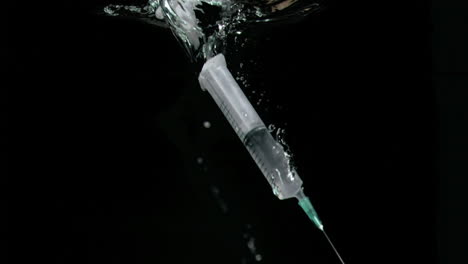 Syringe-in-a-super-slow-motion-falling-vertically-in-the-water-