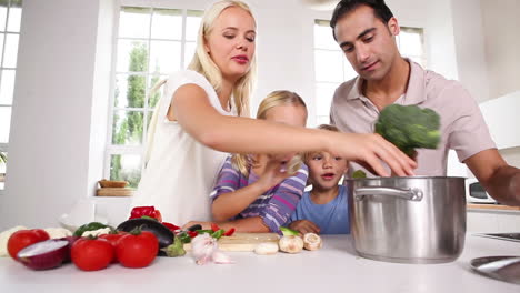 Posing-family-putting-vegetables-in-a-pot