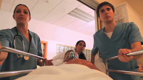 Krankenschwestern-Fahren-Einen-Patienten-Mit-Einer-Sauerstoffmaske-Auf-Seinem-Bett