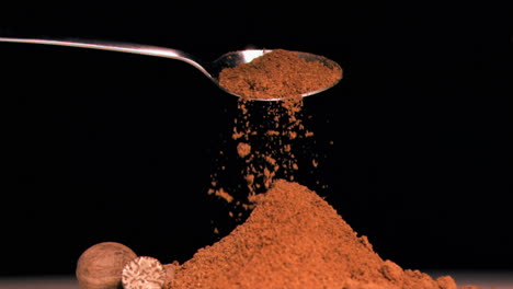 Spoon-pouring-powder-in-super-slow-motion-on-piled-up-powder