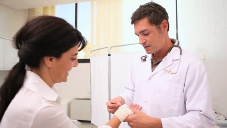Doctor-bandaging-patient-wrist
