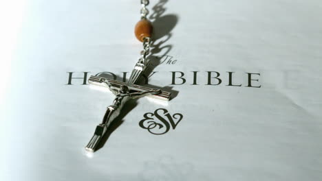 Rosary-beads-falling-onto-first-page-of-bible