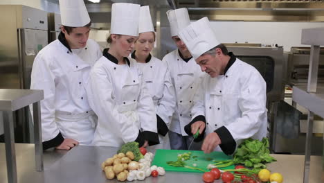 El-Jefe-De-Cocina-Está-Enseñando-A-Cortar-Verduras.